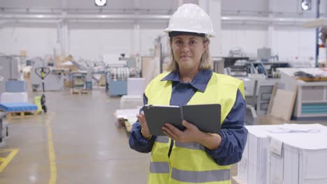 empleada de fábrica de mediana edad mirando a la cámara