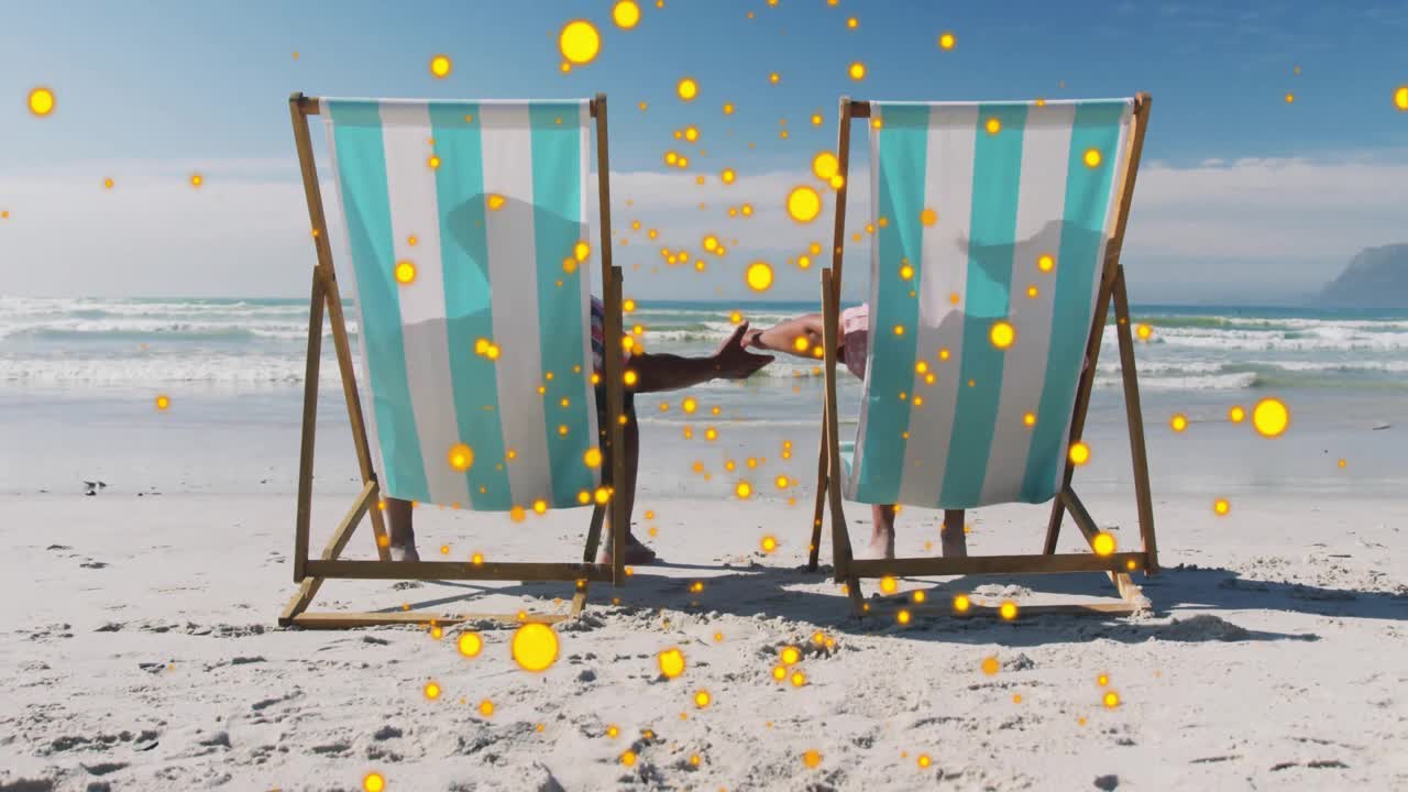 Mature man pushing woman lifting and clasping hands on shore with travel confetti celebrating bond