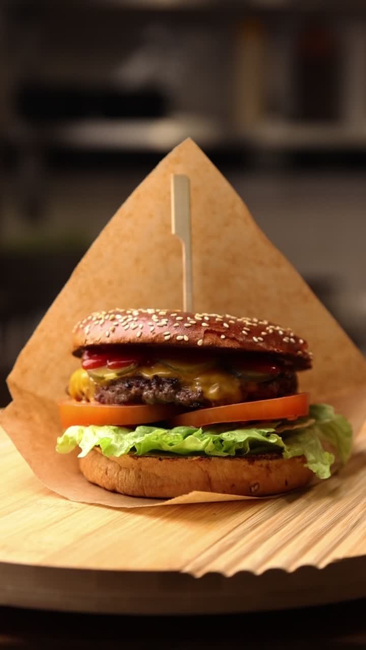 Delizioso cheeseburger gourmet su tagliere di legno.