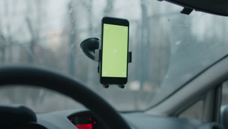 movimiento de deslizamiento y toque con pantalla verde chroma key ready smartphone conectado en el parabrisas del coche en cámara lenta