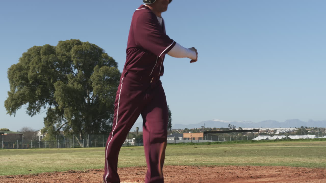 Playing baseball, athlete in uniform standing on base during game