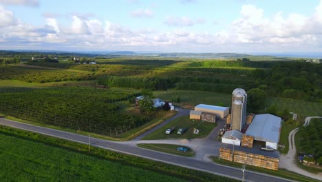 Iconic American farm and silos in green landscape, aerial orbit view