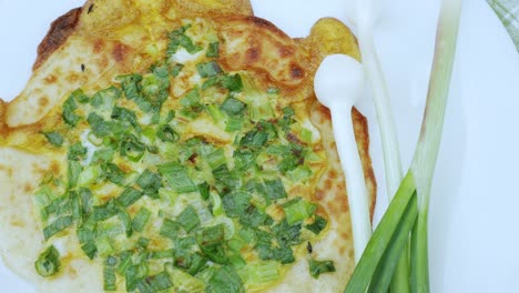 onion pizza on white dish. national cuisine of udmurts: the tabani. onion feathers and tortilla