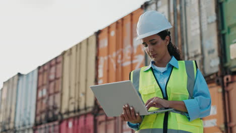 female engineer working on a laptop at a port