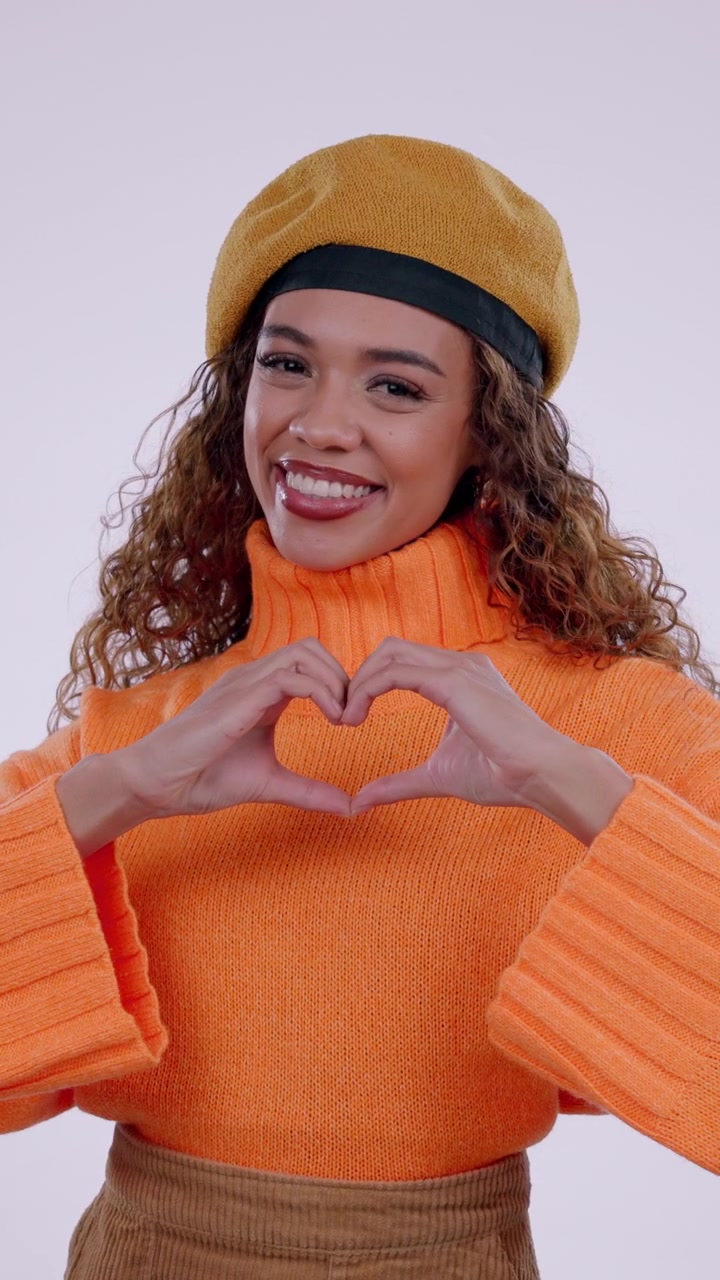 Giovane donna che forma un cuore con le mani