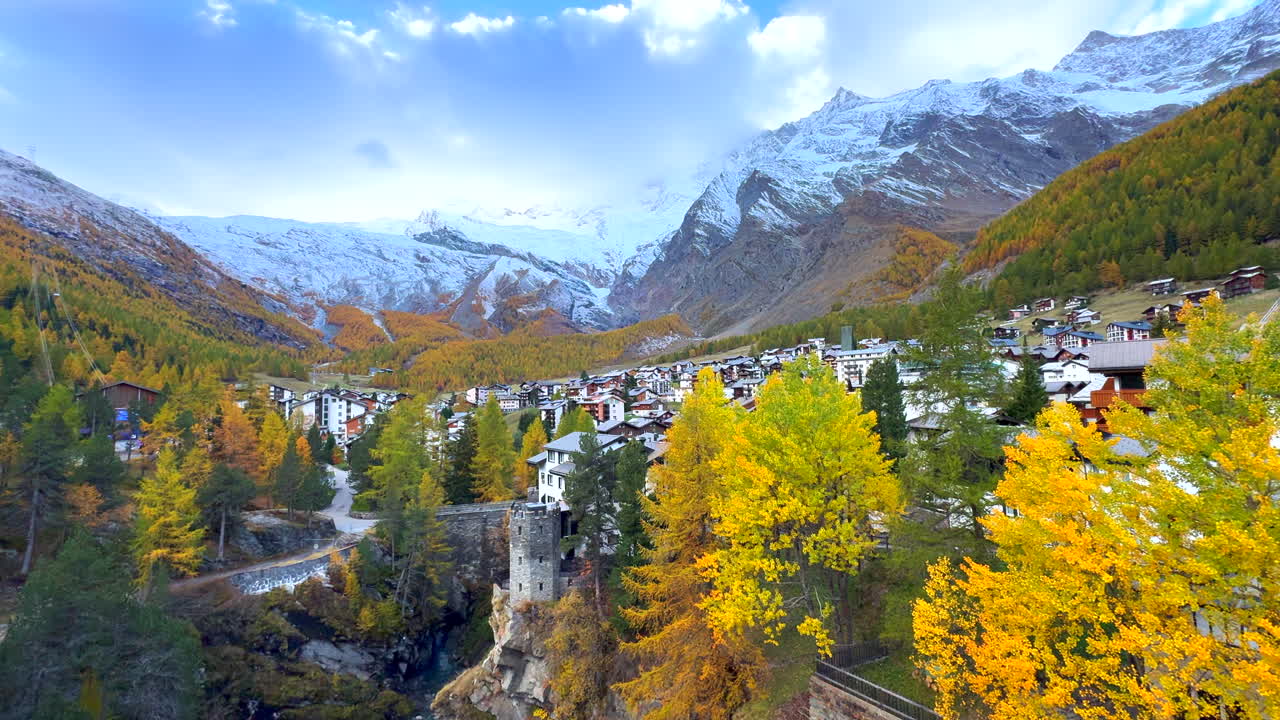 temprano mañana de mal humor saas tarifa zermatt saastal suizo alpes cimas montañosas sombreadas valle alpino chalet estación de esquí ciudad suiza centro del río cruce puente vibrante alondras amarillas lento panorámica a la izquierda