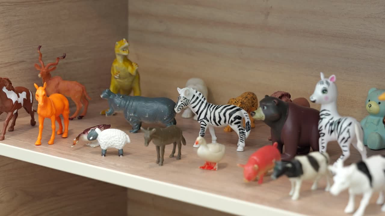 Small plastic toy animals on shelf in kindergarten classroom, close up tracking