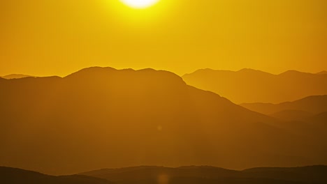 Lapso-De-Tiempo-Puesta-De-Sol-Horizonte-Amarillo-Dorado-Sobre-Picos-De-Montaña-Que-Revelan-La-Caída-De-La-Bola-Del-Sol