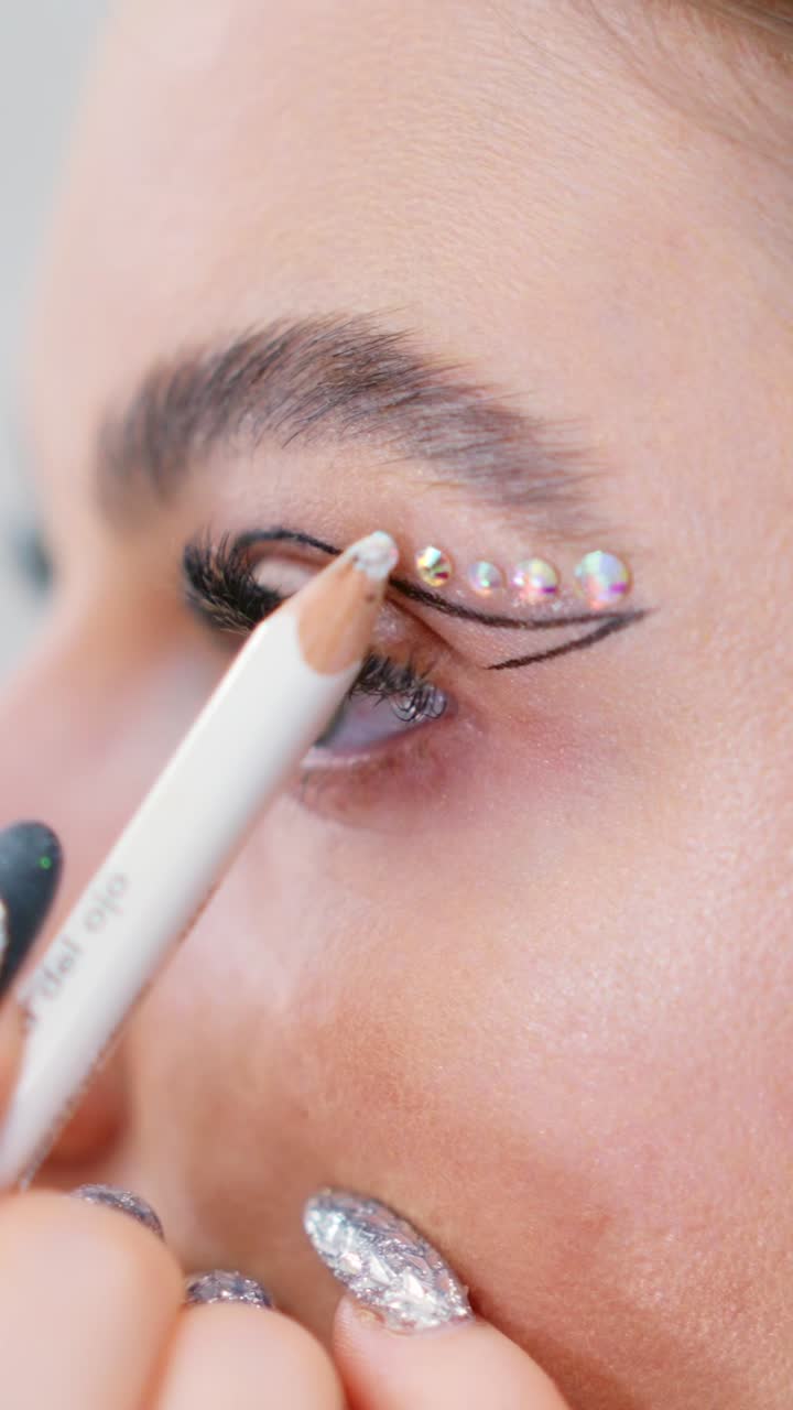 Close-up of Eye Makeup Application with Rhinestones and Winged Eyeliner