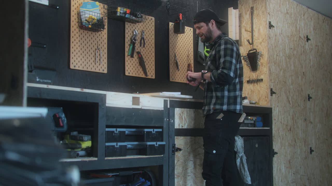 Caucasian bearded man working on the wood plank measuring, indoor workshop