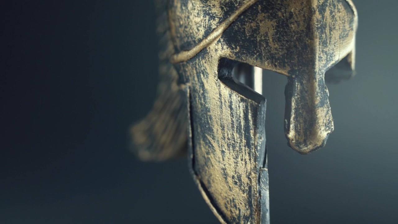 A macro smooth tilt up shot of a spartan design, broken face, warrior metal half helmet, on a 360 rotating stand, studio lighting, 4k video
