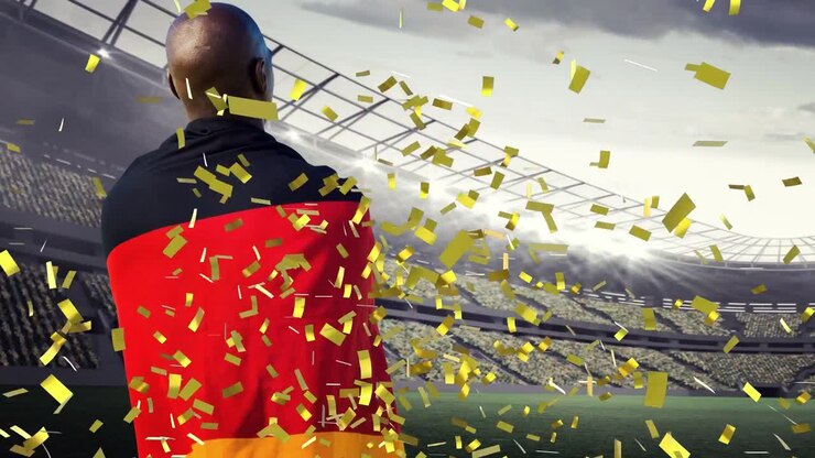 Animazione di coriandoli che fluttuano sulla schiena di un uomo afroamericano con la bandiera tedesca allo stadio.