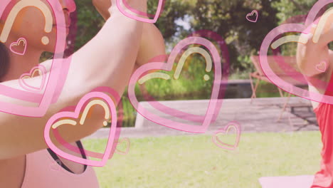 people practicing yoga outdoors with pink heart animations overlaying scene