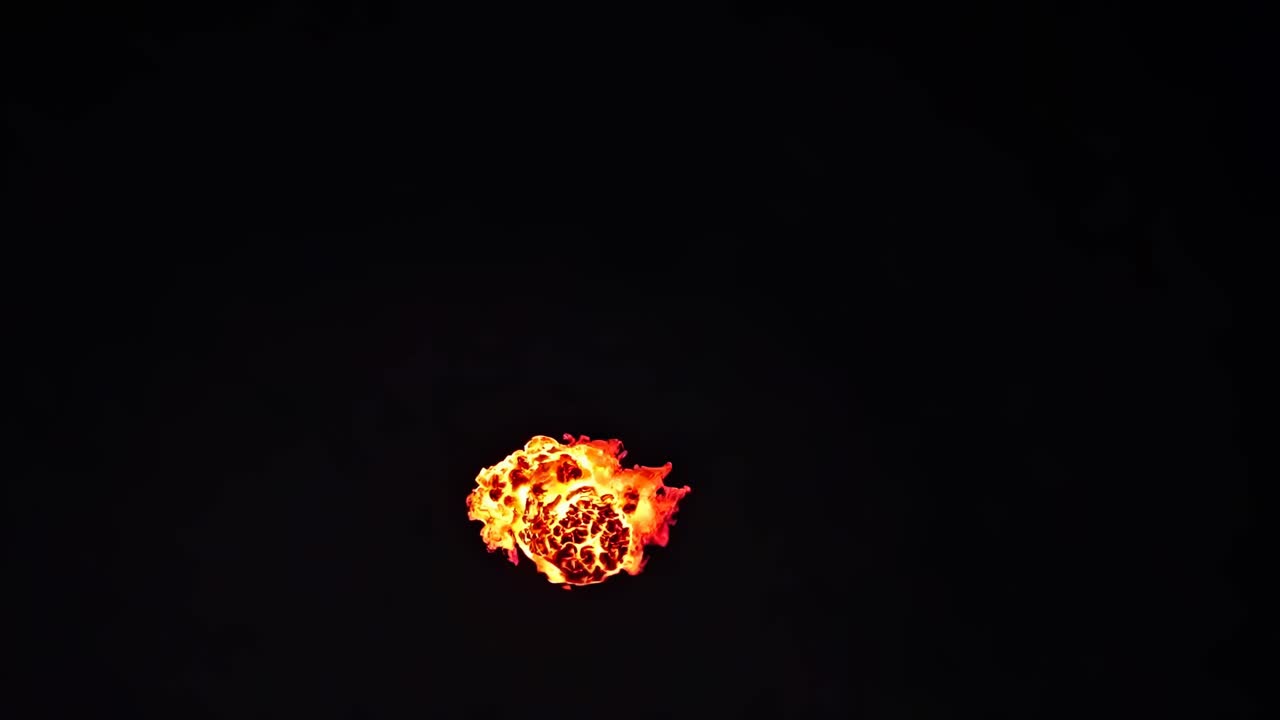 Aerial view of a fiery explosion against a dark background, capturing dynamic motion and intensity