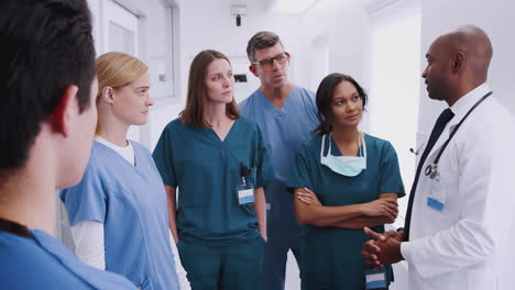 multi-cultural medical team having meeting in hospital corridor