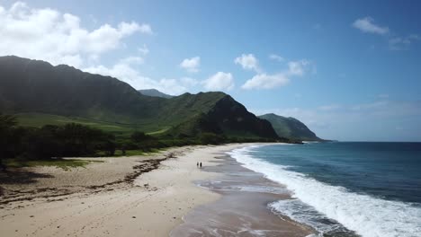 beautiful blue waves and green mountains of makua beach of oahu, hawaii - aerial