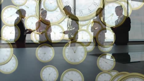 Animation-of-golden-analog-clocks-falling,-sharing-ideas-and-standing-against-glass-window-in-office