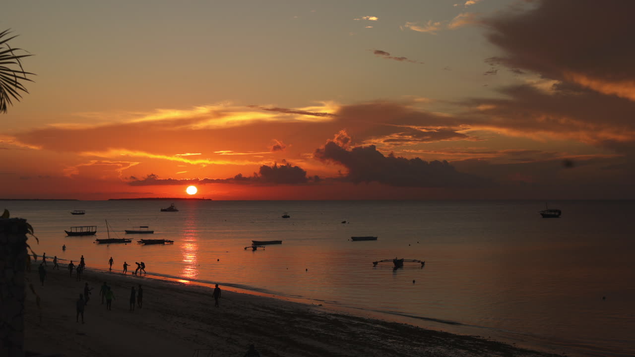 lapso de tiempo - puesta de sol en la playa con barcos, nungwi, zanzíbar, tanzania, plano general