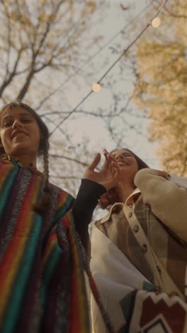 two friends laughing outdoors in autumn