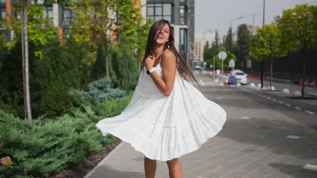 женщина в белом платье наслаждается солнечным днем в городе
