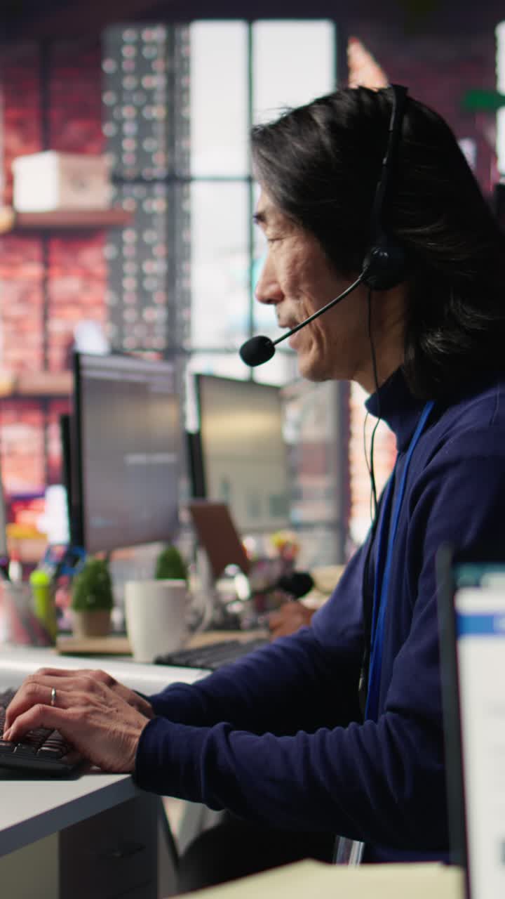 Vertical video Technical support specialist in call center office doing troubleshooting