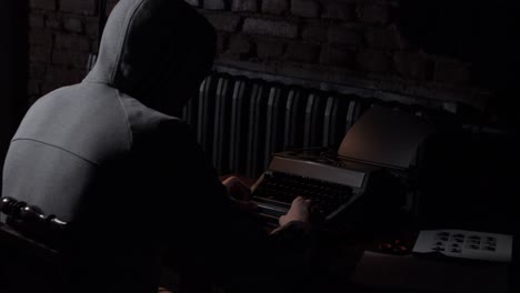 person writing on typewriter in a dark room