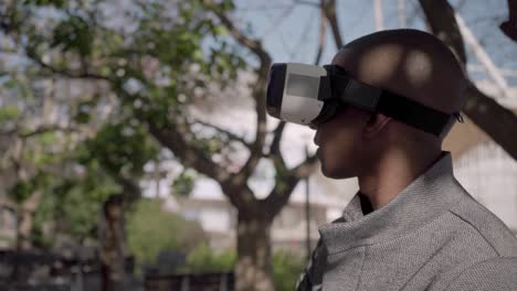 young man using virtual reality glasses on street