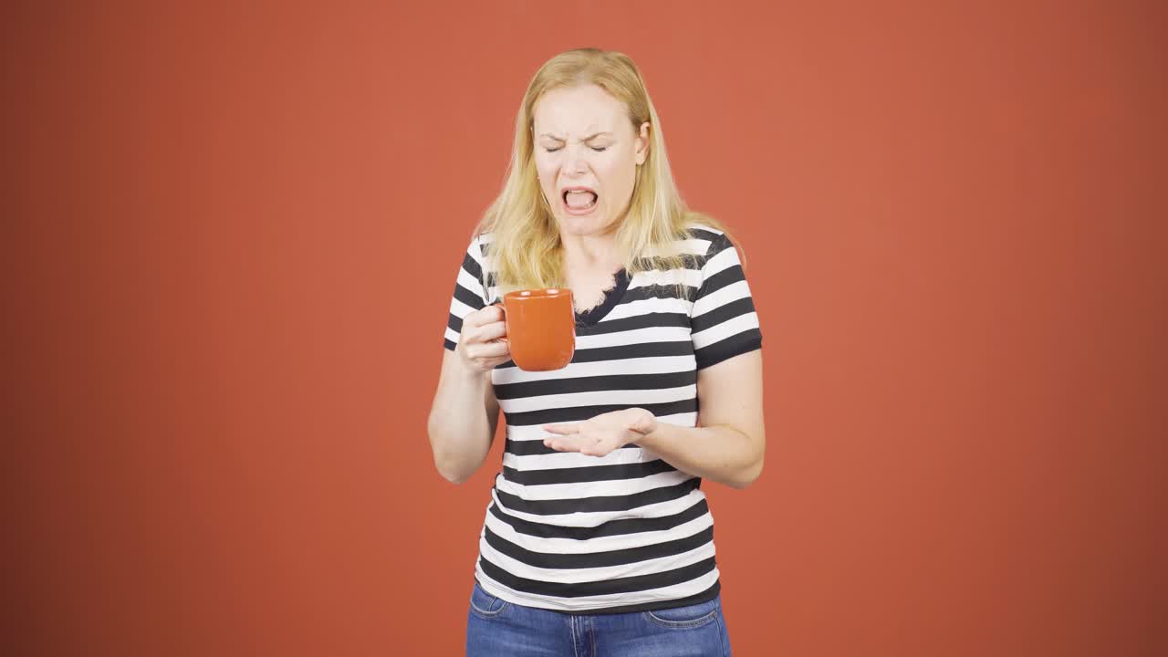 The woman's mouth is burning from the hot drink.