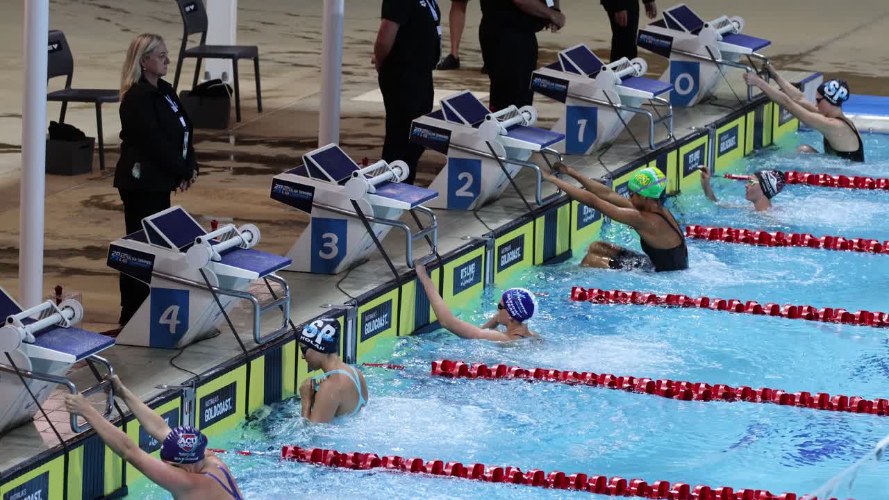 Schwimmer tauchen und liefern sich ein Rennen bei einem Wettkampf.