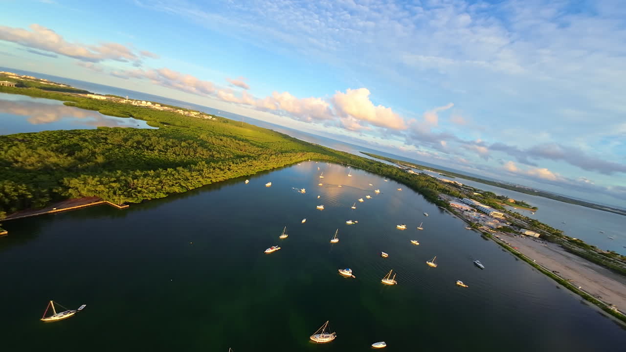 Yachts and boat in the picturesque bay at sunset. FPV drone footage above the waterscape near a big American city.
