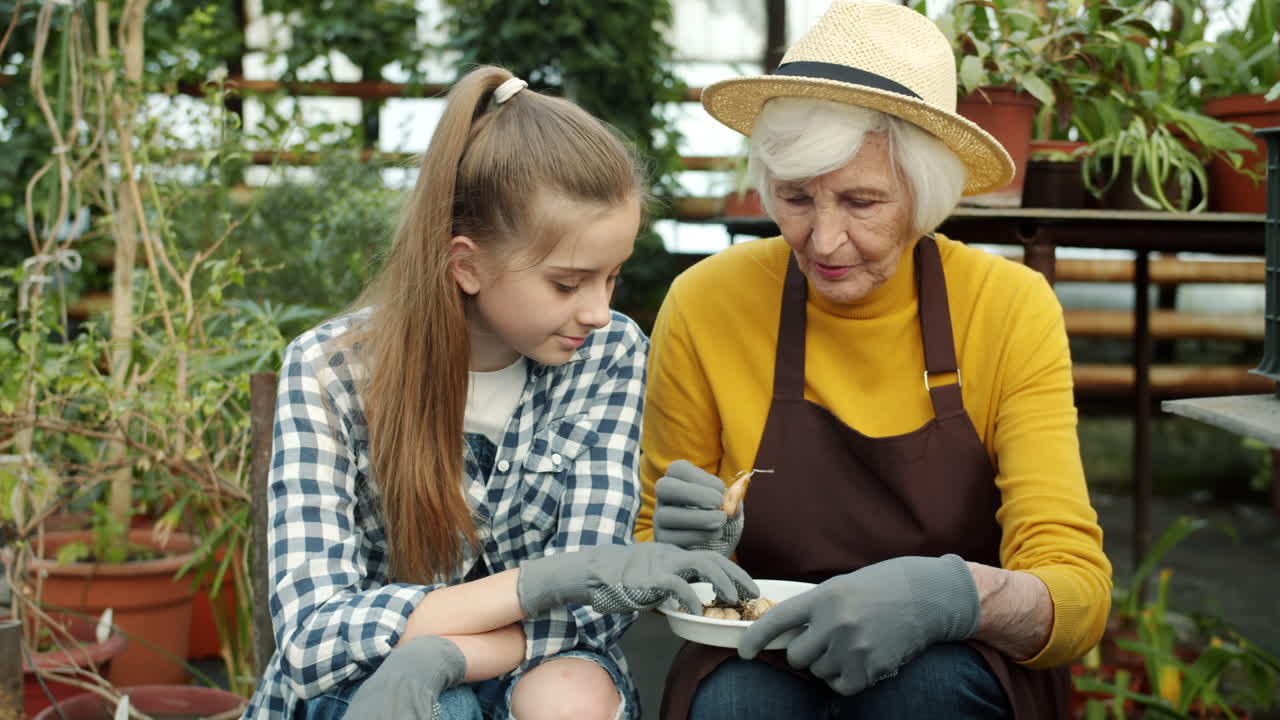 Granddaughter and Grandmother Gardening Together in a Greenhouse