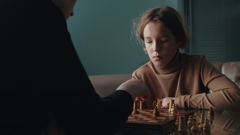 mother and son challenge each other in a game of chess