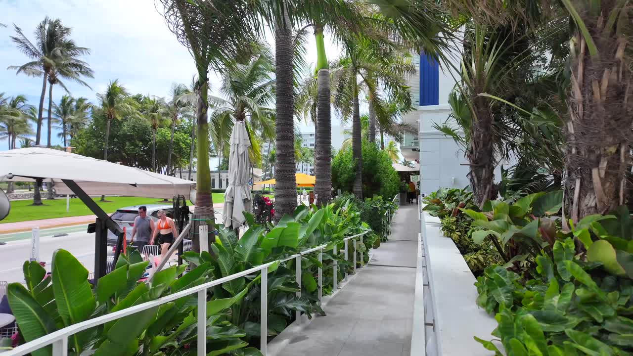 Tourists Couple Walking on Ocean Drive Street in Miami (South Beach area) Florida