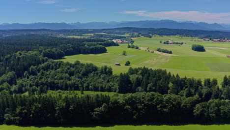 Sanfter-Drohnenflug-über-Grüne-Wiesen-Und-Einen-Kleinen-See-Mit-Luftaufnahme-Der-Alpen---Idyllischer-Ort-Und-Ein-Freizeit-Hintergrundvideo-In-4k