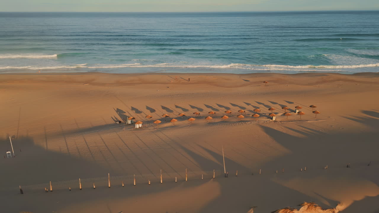 Panoramic view tropical beach ocean surf. Aerial empty recliners and umbrellas