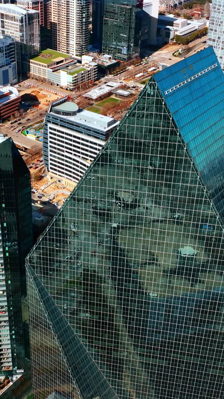 Techos afilados de los rascacielos de espejo reflejando la luz del sol. Imágenes de dron sobre los edificios en la zona alta de Dallas, Texas, EE. UU.