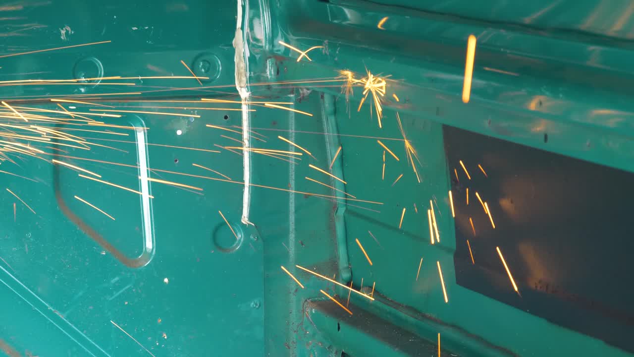 밴 격벽 강철을 절단하는 앵글 그라인더에서 불꽃이 튀었습니다.