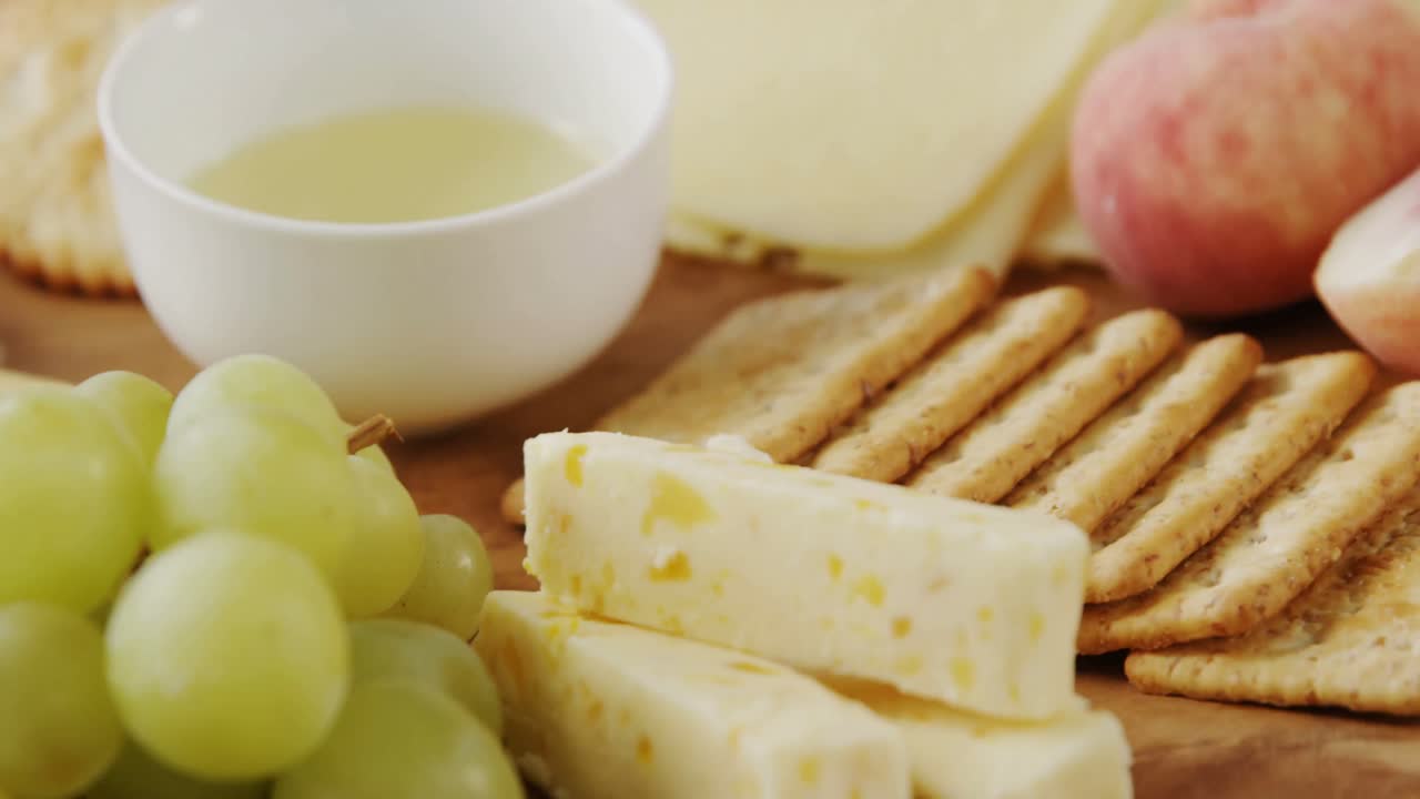 diferentes tipos de queso con galletas crujientes, frutas y salsa