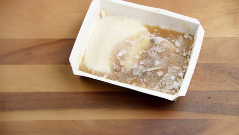 desperdicio de comida comida congelada caja de bocadillos en un recipiente blanco que se arroja sobre una mesa de comedor