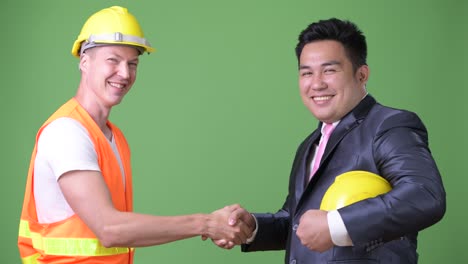 scandinavian man construction worker and asian businessman working together