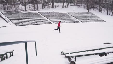 Young-man-with-red-hoodie-and-black-pants-begins-to-run-outside-in-winter