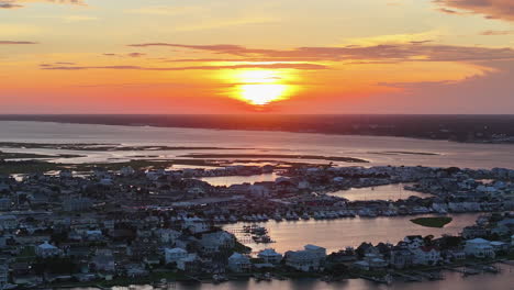 Cinematic-drone-shot-of-sun-setting-over-Atlantic-Beach-North-Carolina,-slow-revealing-aerial-shot