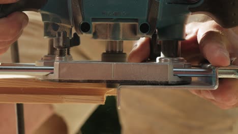 Hands-of-man-working-with-wood-outdoors-using-electrical-machine,-close-up