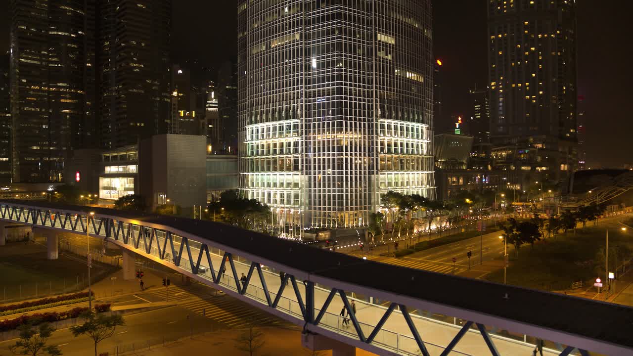 paisaje urbano de hong kong por la noche con puente peatonal