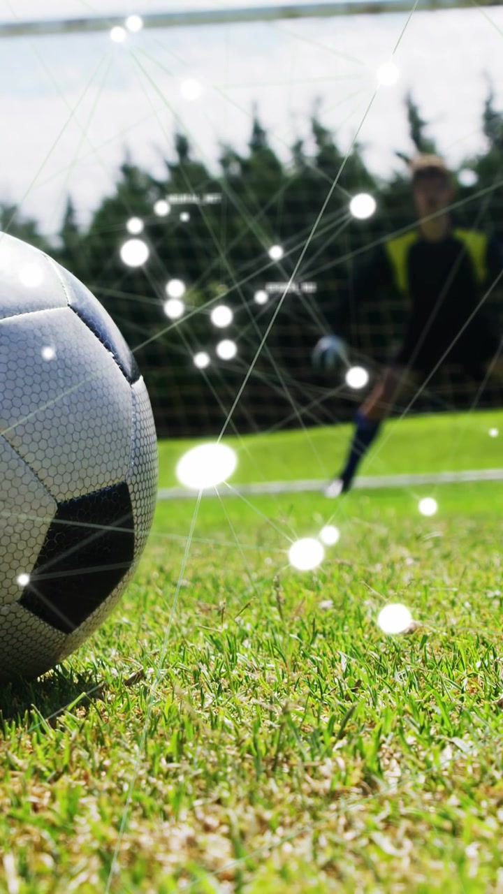 Vertikal video: Spark uden for billedet sender fodbolden afsted, mens prikker stiger op nær målmanden, der dykker for at redde.