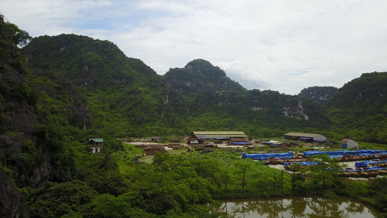 Discover the unique aerial perspective of an agricultural area nestled near the impressive rock formations of Ninh Binh, Vietnam. This view highlights the interplay between human activity.