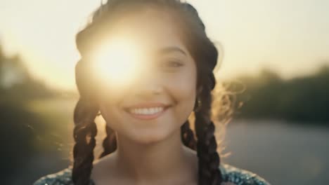 beautiful woman with braids smiling at sunset