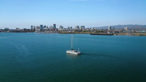 Ein-Einsames-Segelboot-Treibt-An-Einem-Sonnigen-Tag-Mit-Dem-Wind-In-Einer-Wunderschönen-Bucht