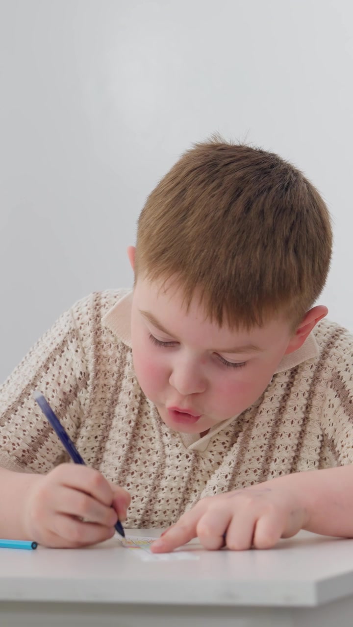 Giovane ragazzo concentrato mentre disegna con una penna