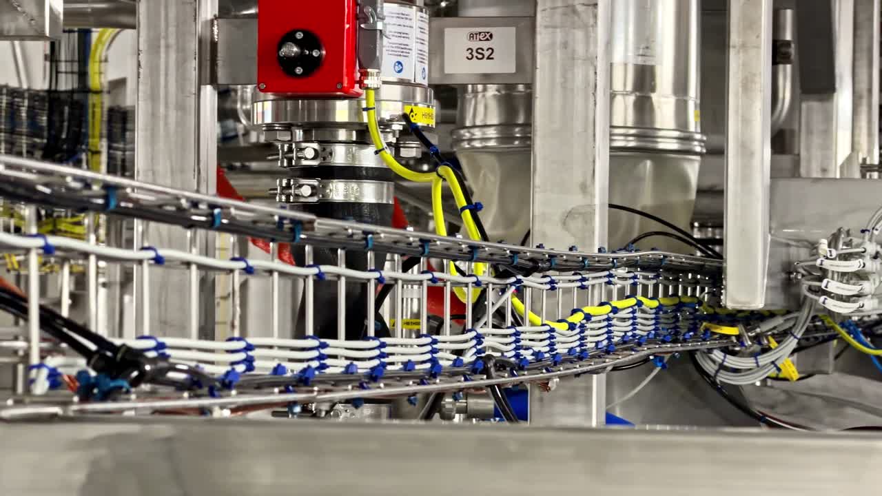 Close-Up Of Industrial Automated Packaging Machine With Cable Trays And Control Component In Manufacturing Facility